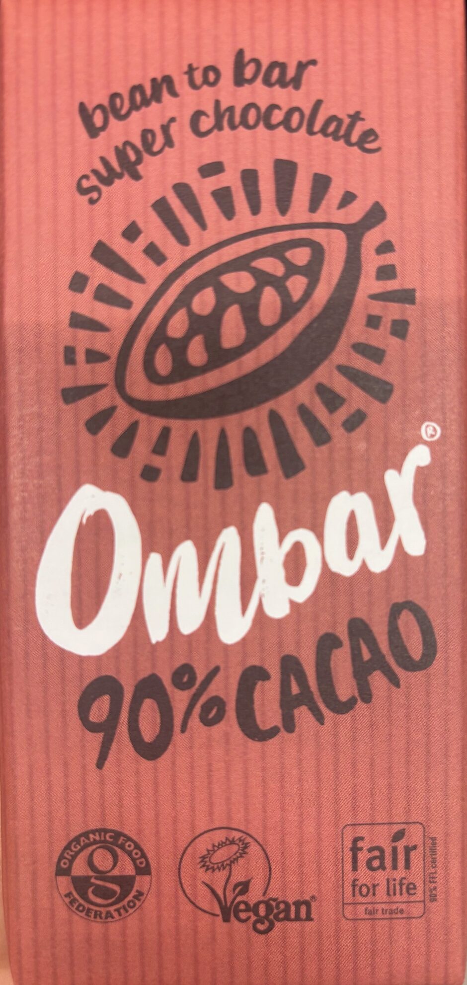 Front of Ombar 90% Cacao. Coral colored packaging with an image of a cacao bean